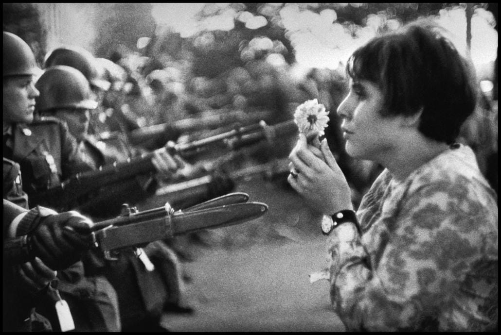 Marc Riboud Một cô gái trẻ người Mỹ, Jan Rose Kasmir, đối đầu với Vệ binh Quốc gia Hoa Kỳ bên ngoài Lầu Năm Góc trong cuộc tuần hành phản đối chiến tranh Việt Nam năm 1967